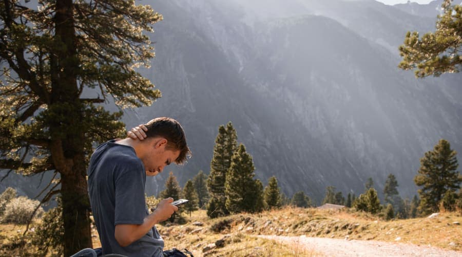 Randonneur en montagne utilisant équipement moderne et technologie connectée