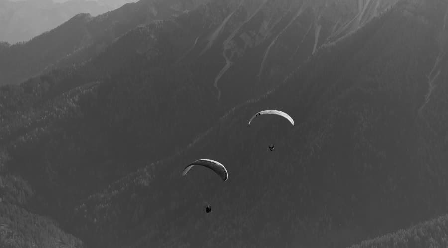 Parapentiste en vol au-dessus des sommets pyrénéens avec vue panoramique